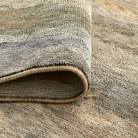 Multi-colored modern abstract patterned rug with soft beige, tan, gray, and muted blue tones and a 10mm pile.