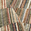 Multi-colored striped rug with earthy tones of tan, brown, blue, and cream in a soft, textured polyester pile.