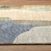 Tanami 336 rug with abstract multi-colored pattern in beige, blue, green, and gray tones on wooden floor.