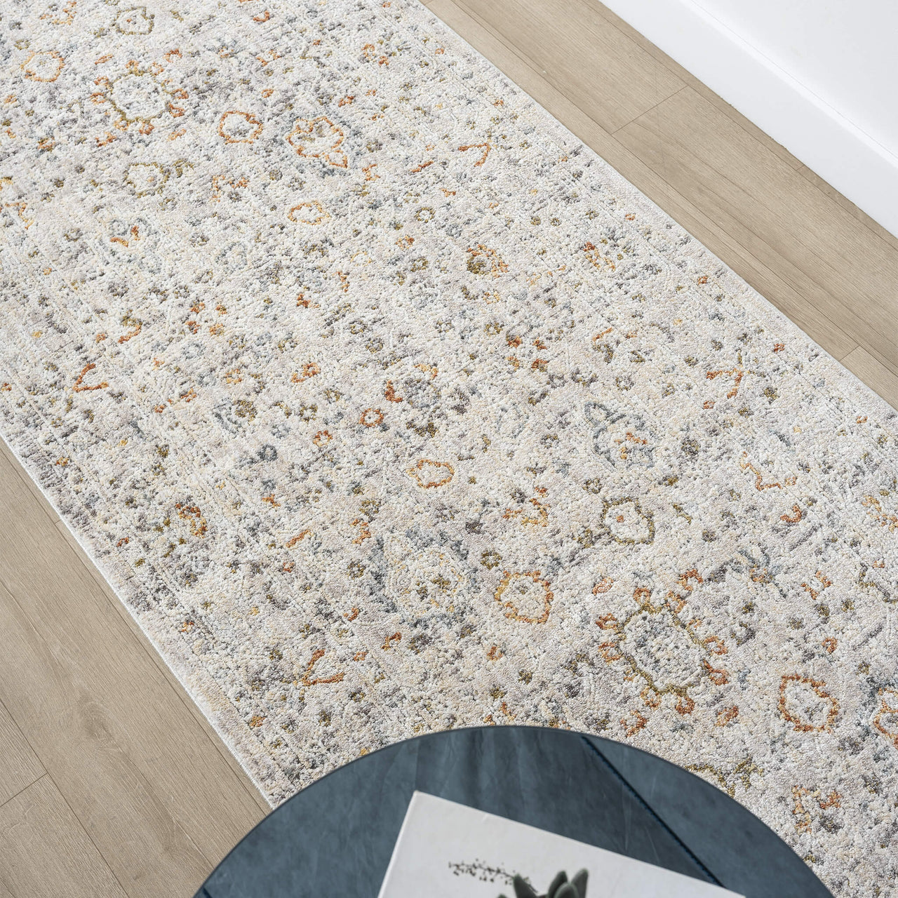Patterned rug on a wooden floor with a chair partially visible