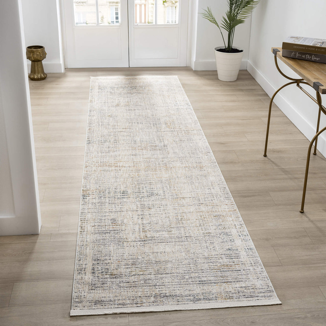Long rectangular runner rug on a wooden floor with a plant and bench in the background