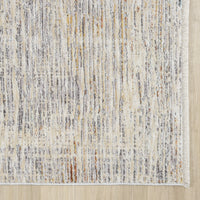 Textured area rug with a neutral color palette on a wooden floor.