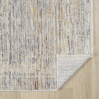 Textured area rug with a neutral color palette on a wooden floor.