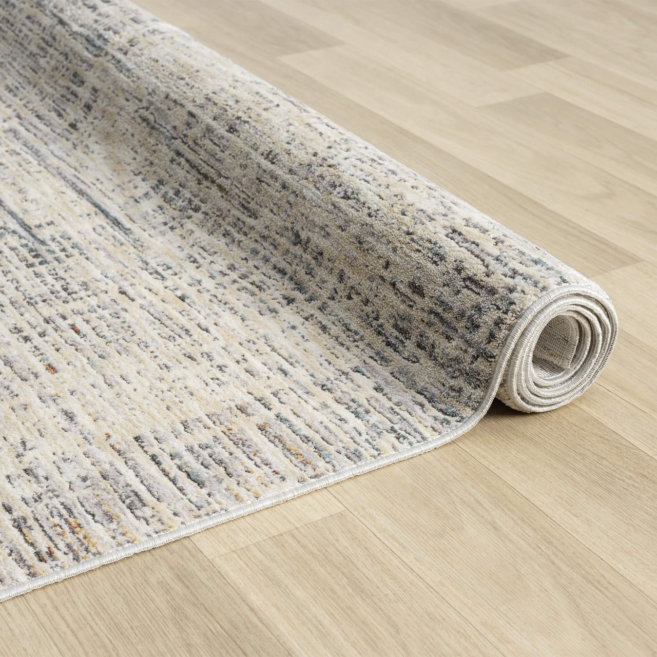 Rolled-up textured rug on a wooden floor