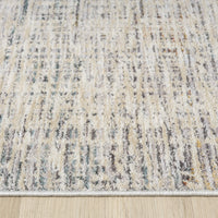 Close-up of a textured area rug with neutral colors on a wooden floor.