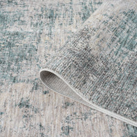 Textured area rug with a patterned design, showing a roll of the rug.