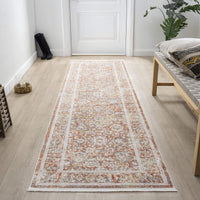 Long rectangular rug with a pattern on a wooden floor in a room with a bench and plant.