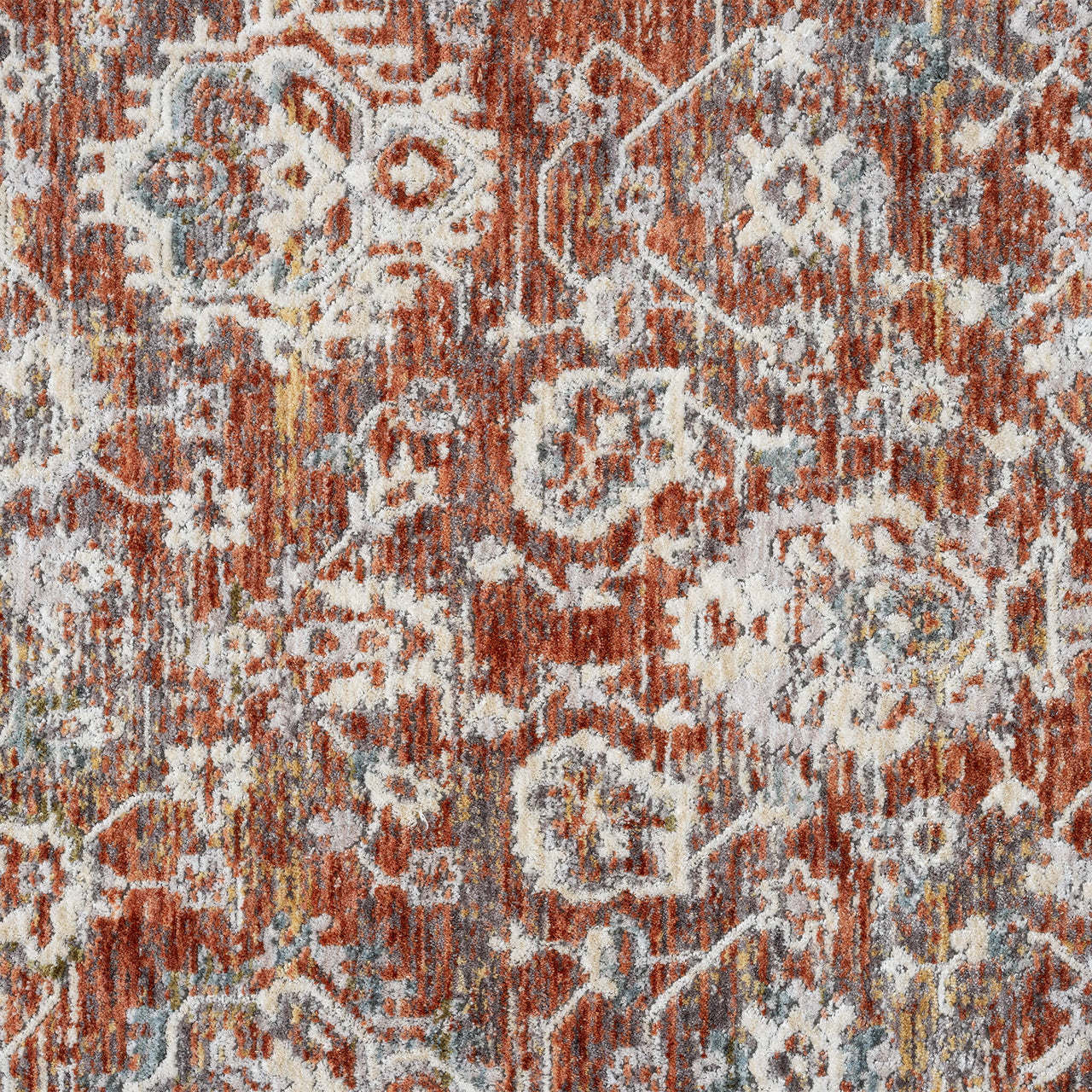 Close-up of a patterned rug with red, beige, and brown colors.