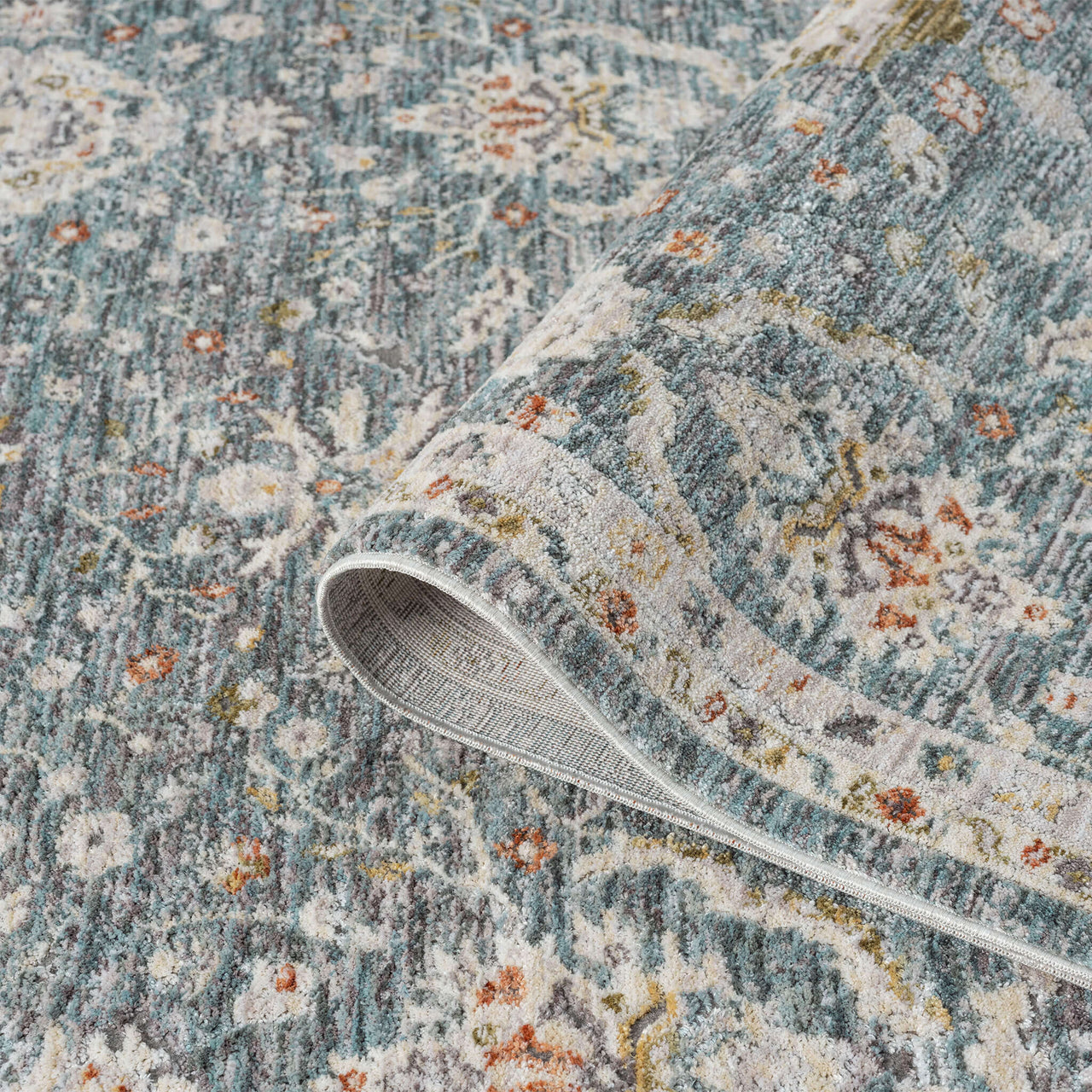 Blue runner rug with intricate floral pattern in cream, orange, and muted green tones, soft textured polyester weave.