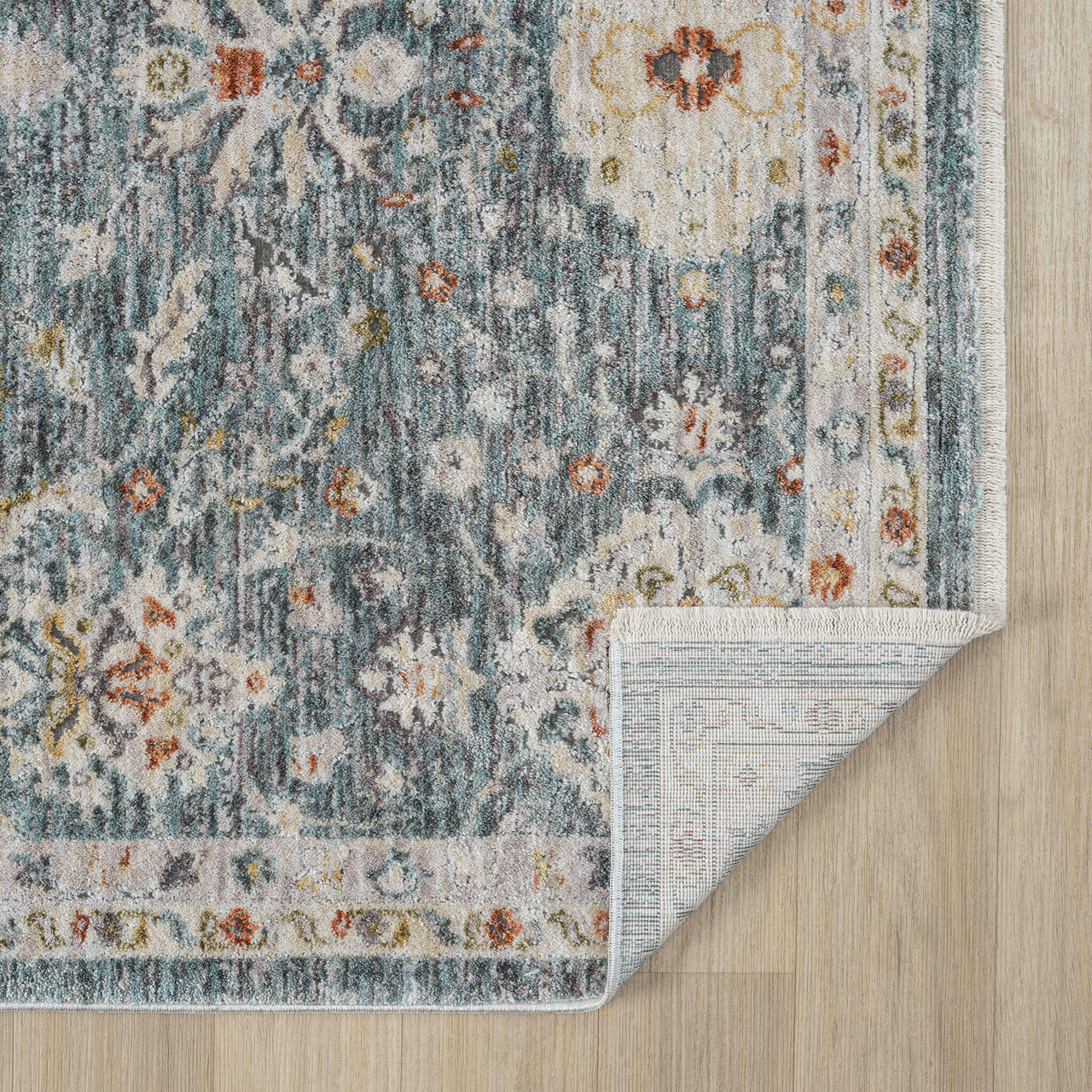 Blue floral patterned transitional runner rug with distressed vintage design and subtle beige border on wood floor.