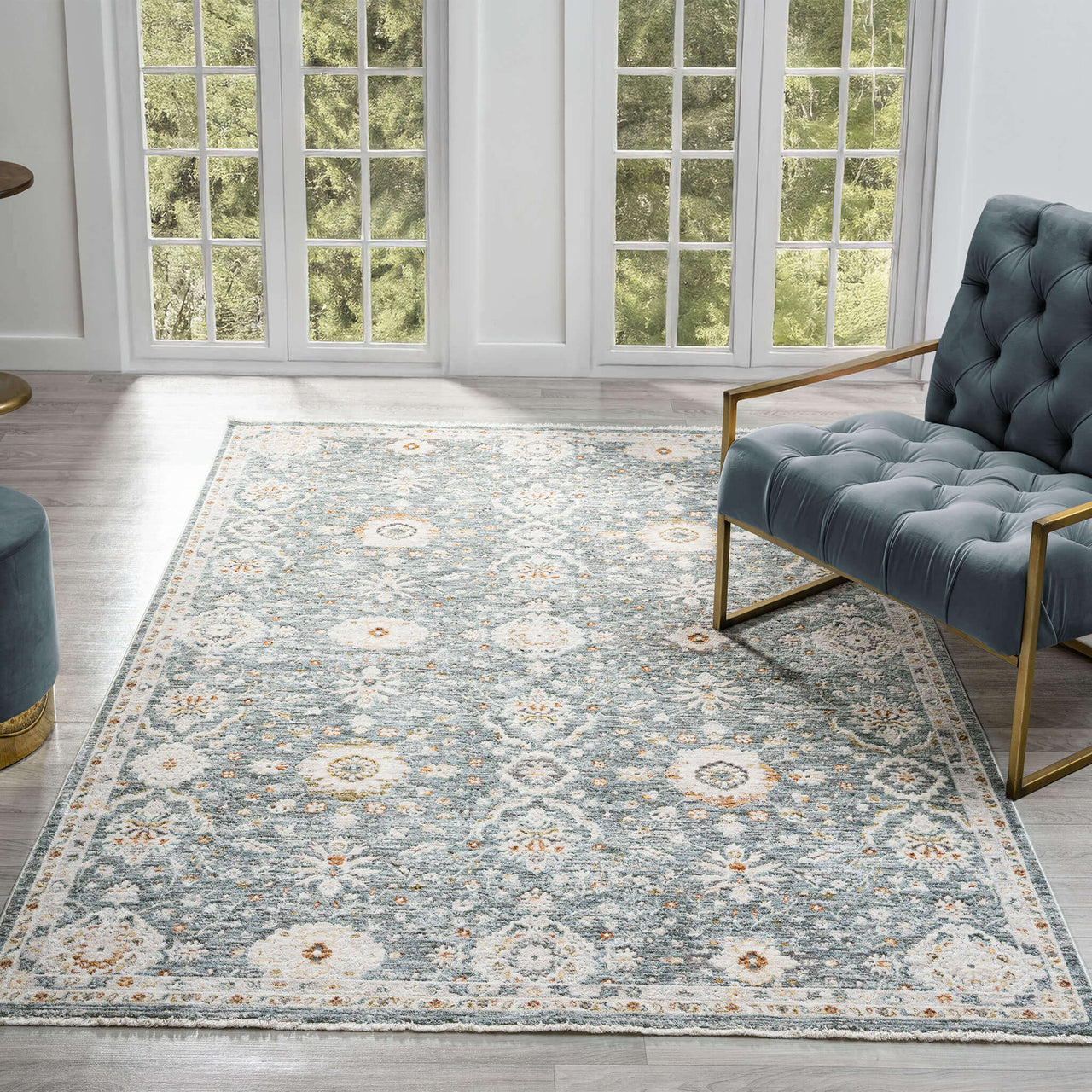 Blue multi-colored floral patterned transitional rug with intricate symmetrical design on hardwood floor.