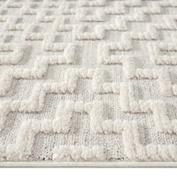 Grey rug with raised geometric textured pattern in soft polyester fibers.