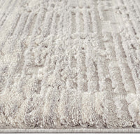 Light grey modern rug with geometric textured pile and subtle raised patterns.
