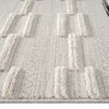 Grey rug with raised rectangular geometric patterns and a textured polyester pile.