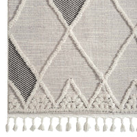 Grey runner rug with textured diamond geometric pattern and white tassels on edges.