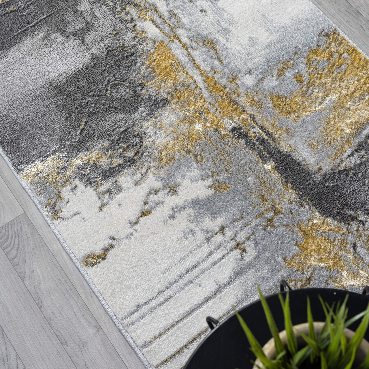 Grey runner rug with abstract gold and black textured pattern on a soft pile surface.