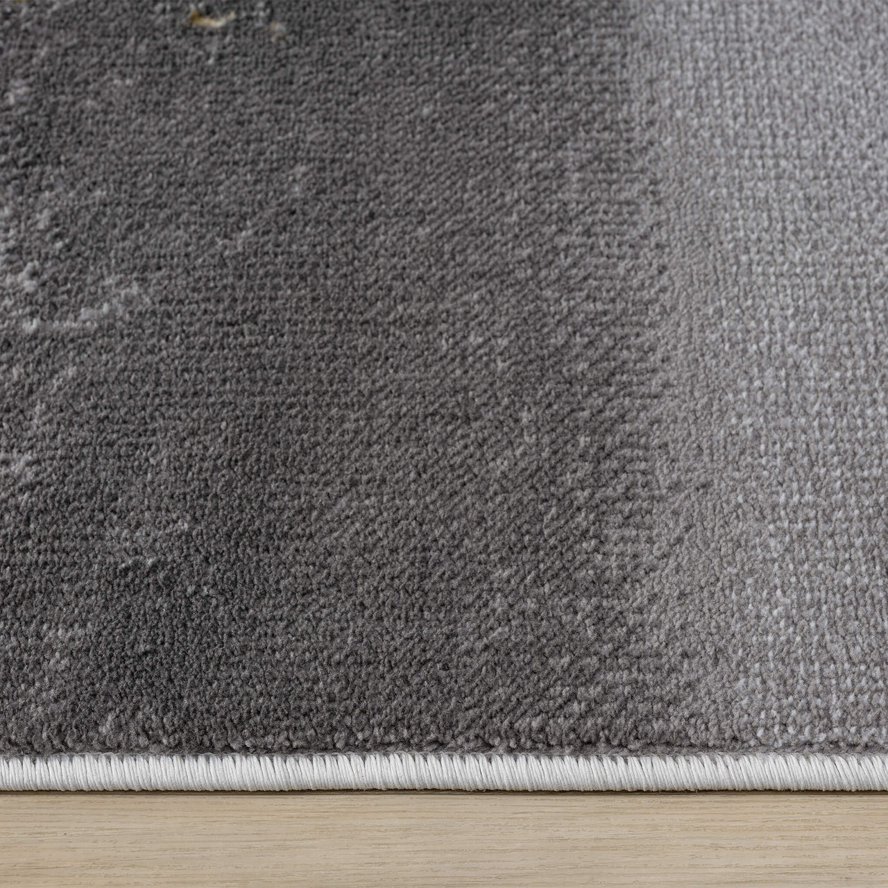 Grey modern runner rug with subtle gradient texture and stitched edges.