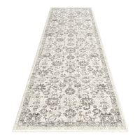 Modern cream and grey runner rug with intricate floral and geometric pattern and fringed edges.