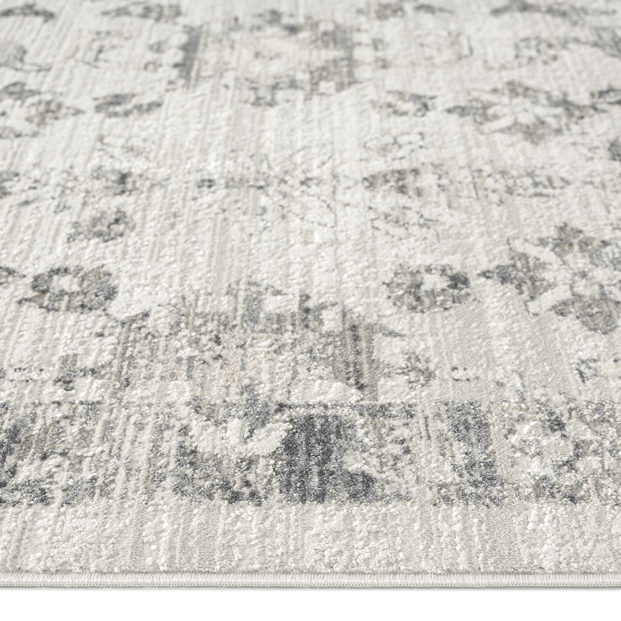 Modern cream and grey patterned runner rug with subtle distressed floral motifs and textured weave.