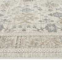 Light neutral rug with subtle geometric and floral motifs in beige and grey tones.
