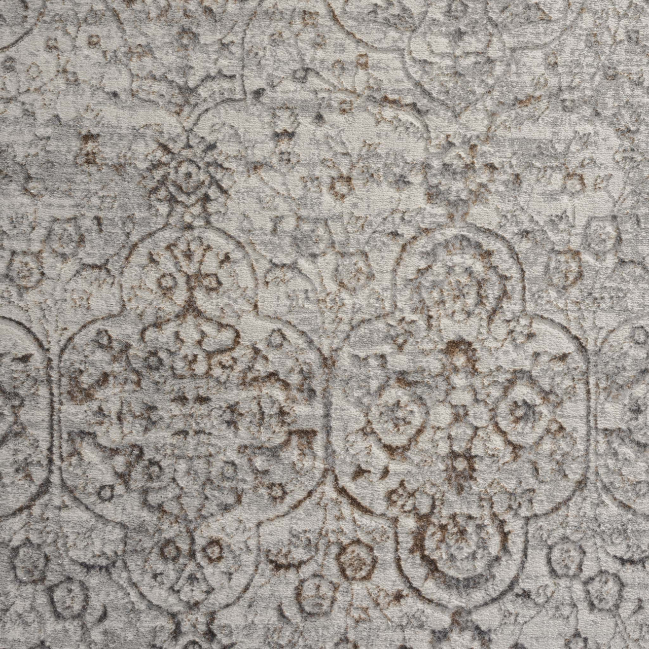 Grey beige rug with intricate faded floral and geometric pattern in a modern vintage style.