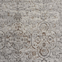 Grey beige rug with intricate faded floral and geometric pattern in a modern vintage style.