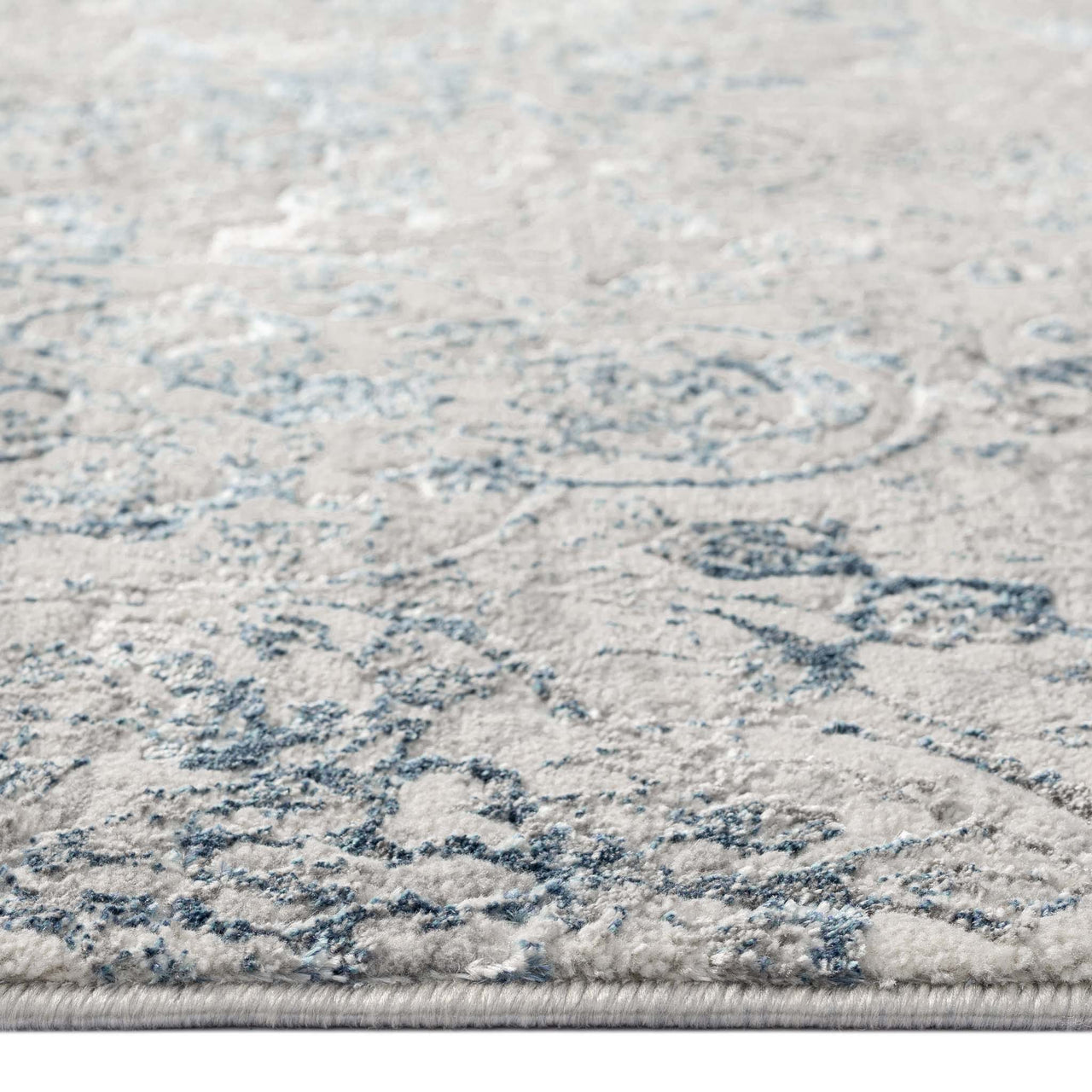 Grey blue runner rug with subtle multi-color floral and swirl pattern, low pile texture.