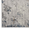 Grey modern rug with subtle floral and geometric patterns in blue and beige tones, textured polyester weave.
