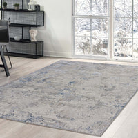 Grey patterned modern rug with subtle abstract design on light wood floor in bright room.