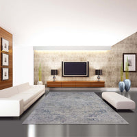 Grey-blue modern rug with subtle abstract pattern in minimalist living room setting.