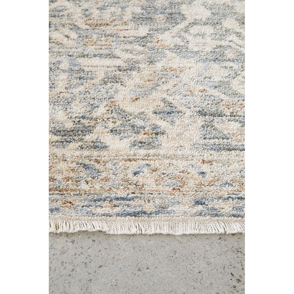 Close-up of a textured rug with a geometric pattern on a concrete floor.