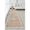 Long rectangular rug on a concrete floor in a living room setting with a sofa and side table.
