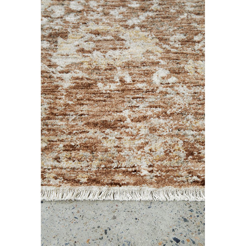 Textured brown and beige rug on a concrete floor