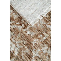 Close-up of a textured beige and brown area rug with fringed edge.