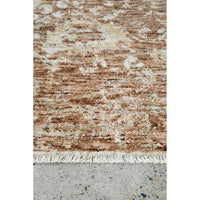 Textured brown and beige rug on a concrete floor