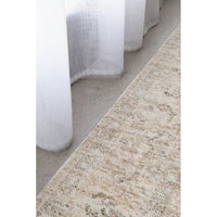 Close-up of a textured beige runner rug with white curtains in the background