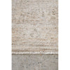 Textured beige runner rug with a concrete floor underneath
