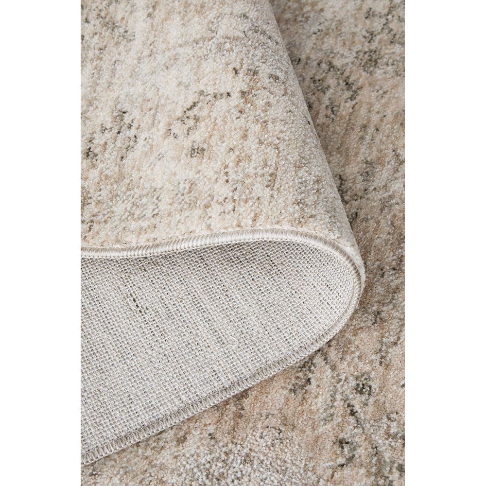 Close-up of a textured beige rug corner on a neutral background
