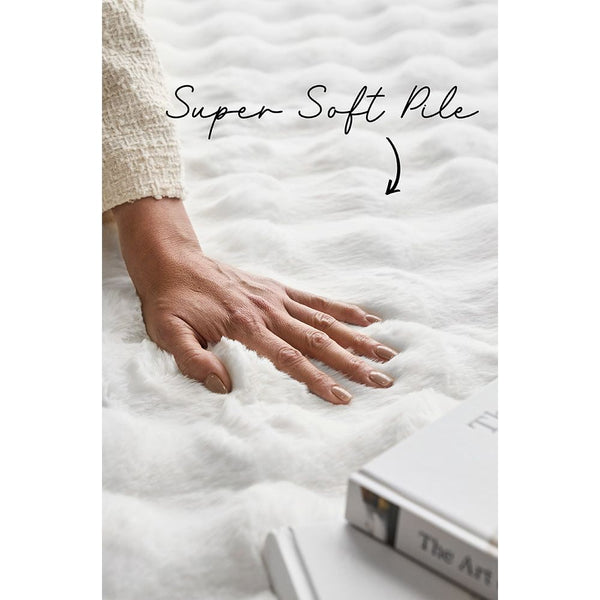 Hand pressing soft white textured pile on modern machine-washable rug.
