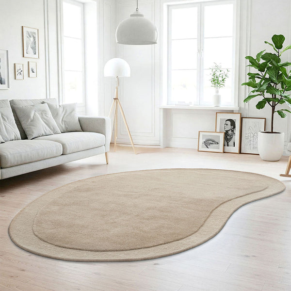 Curved beige wool rug with subtle two-tone border in bright modern living room.