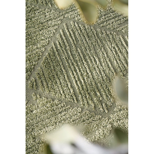 Close-up of emerald green rug with textured diamond pattern and soft polyester pile.