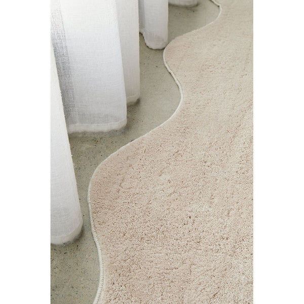 Beige machine washable modern rug with soft texture and wavy edge detail.