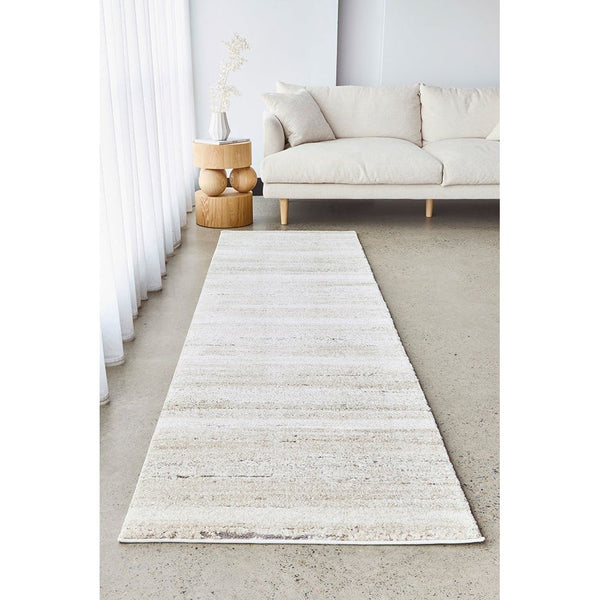 Cream multi-colored runner rug with subtle abstract pattern in a modern living room setting.