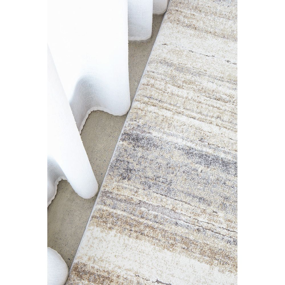 Close-up of a textured area rug with neutral colors on a light background