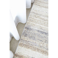 Close-up of a textured area rug with neutral colors on a light background