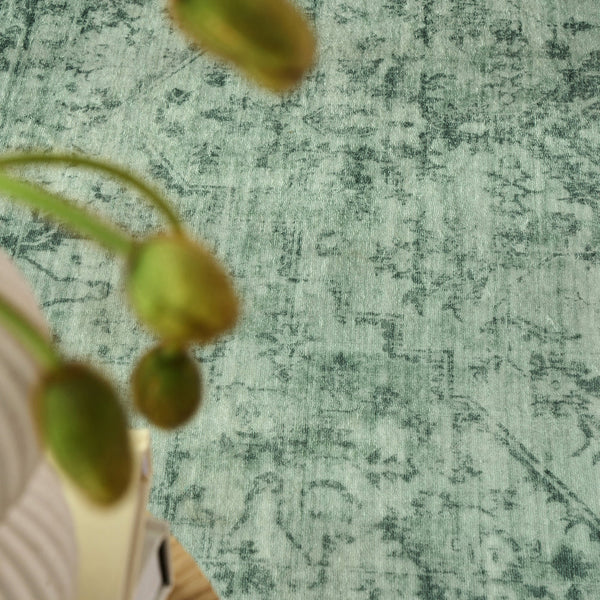 Emerald green modern rug with subtle distressed pattern and soft texture.
