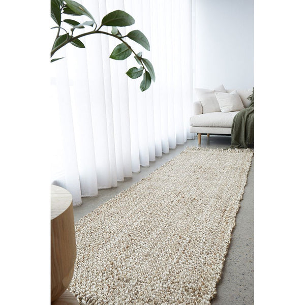 Hand-loomed silver grey jute runner rug with natural woven texture on light floor.