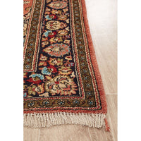 Decorative hand knotted Persian silk rug with intricate patterns on a wooden floor