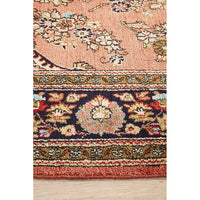 Close-up of a patterned hand knotted Persian silk rug with floral designs on a wooden floor.