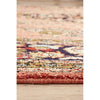 Close-up of a multicolored patterned hand knotted Persian silk rug on a wooden floor.